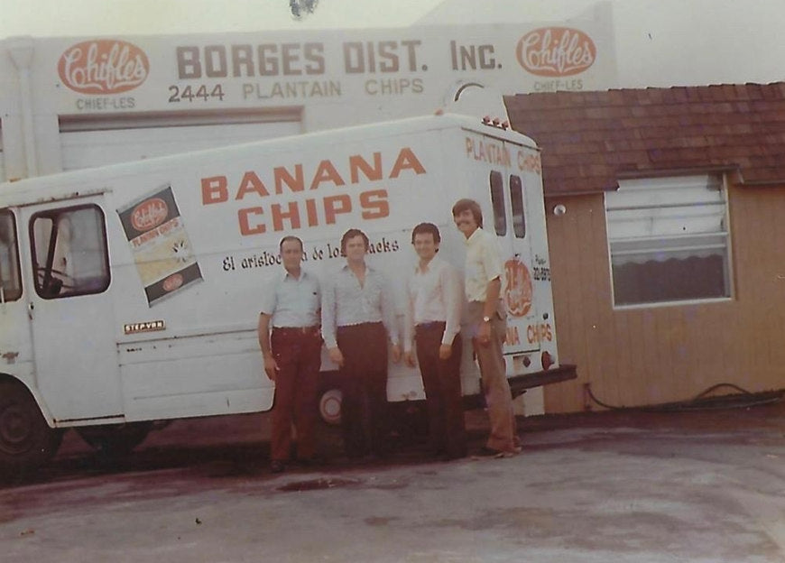 Four men beside a Chifles delivery truck at the original distribution warehouse in the 1970s